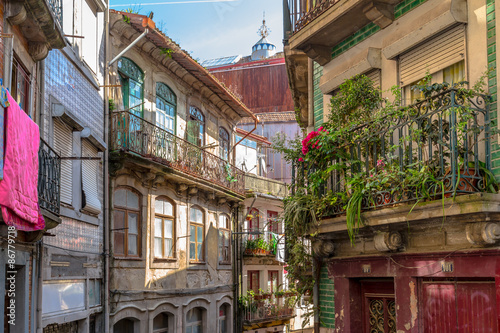 Old and ruined alley decorated with plants in downtown Porto.