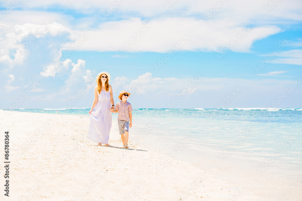 Happy beautiful mother in long white dress enjoying beach time Happy beautiful mother in long white dress enjoying beach time