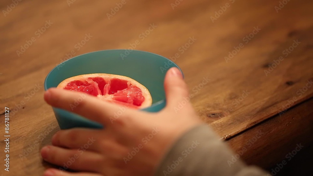 A closeup of eating a ruby red grapefruit A closeup of eating a ruby red grapefruit