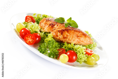 Roast chicken fillet and vegetables on white background