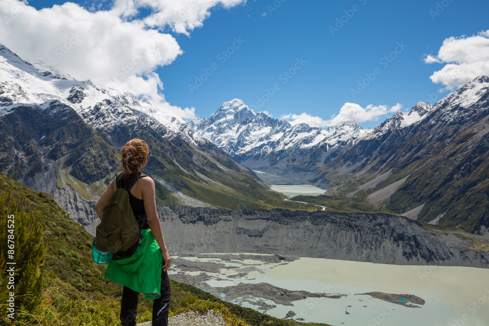 Naklejka premium Woman Traveler with Backpack hiking in Mountains