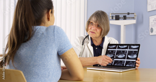Senior doctor reviewing Mexican woman s pregnancy scans