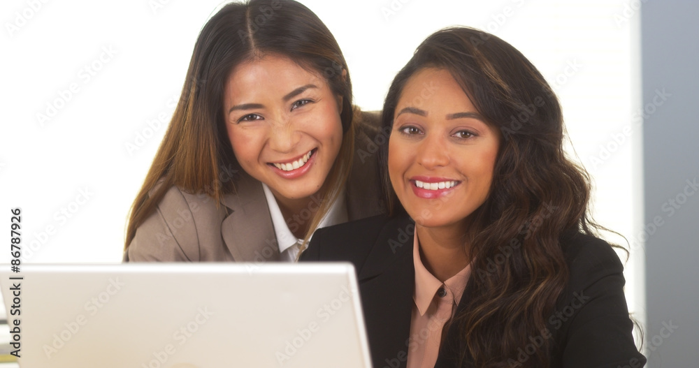 Mixed race businesswomen smiling at camera Mixed race businesswomen smiling at camera