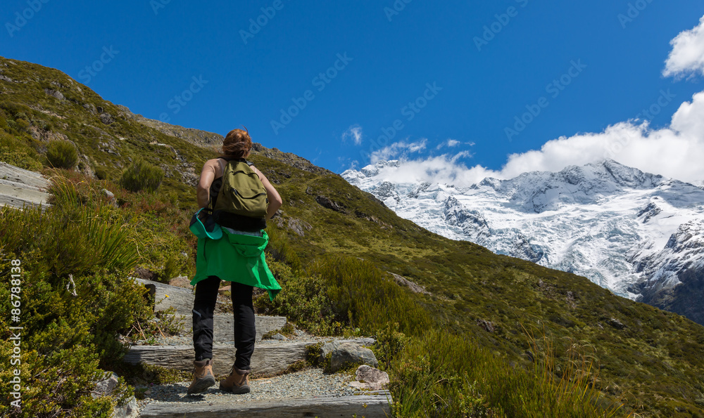 Woman Traveler with Backpack hiking in Mountains
