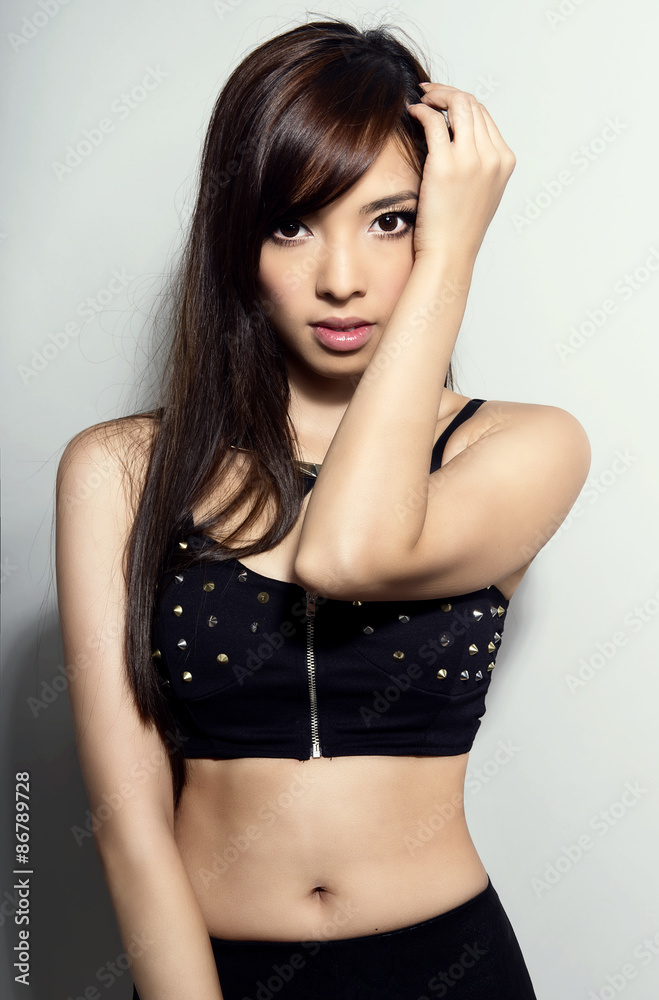 beautiful asian woman with long hair posing on grey background