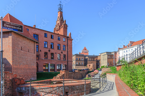 Poznań, stare miasto - fragment odrestaurowanych murów miejskich oraz budynek komendy straży pozarnej z wieżą obserwacyjną przy skwerze Dworzaczka