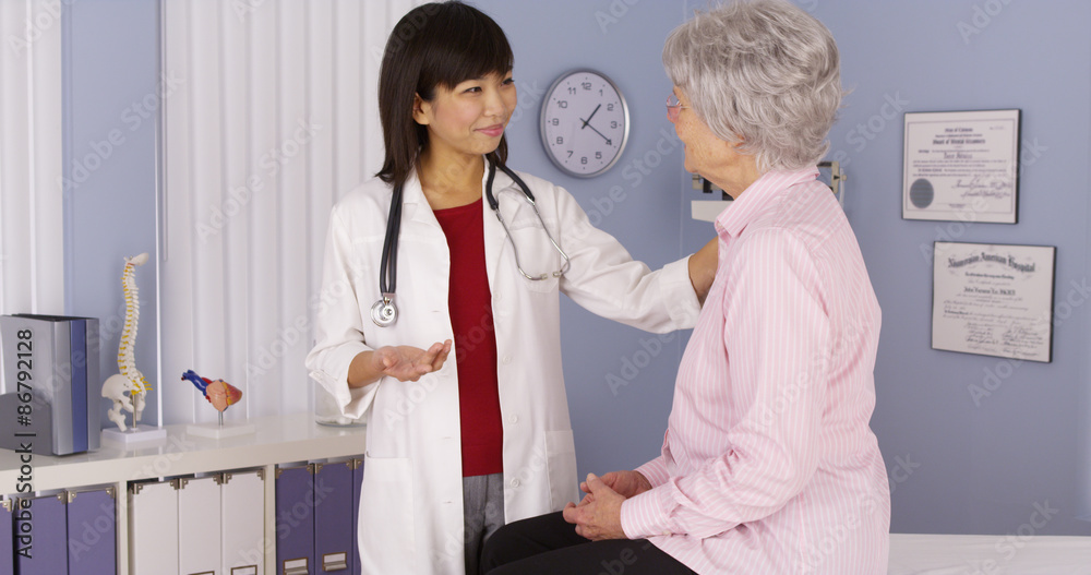 Fototapeta premium Chinese doctor talking to elderly patient