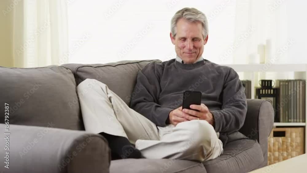Senior man using smartphone smiling Senior man using smartphone smiling