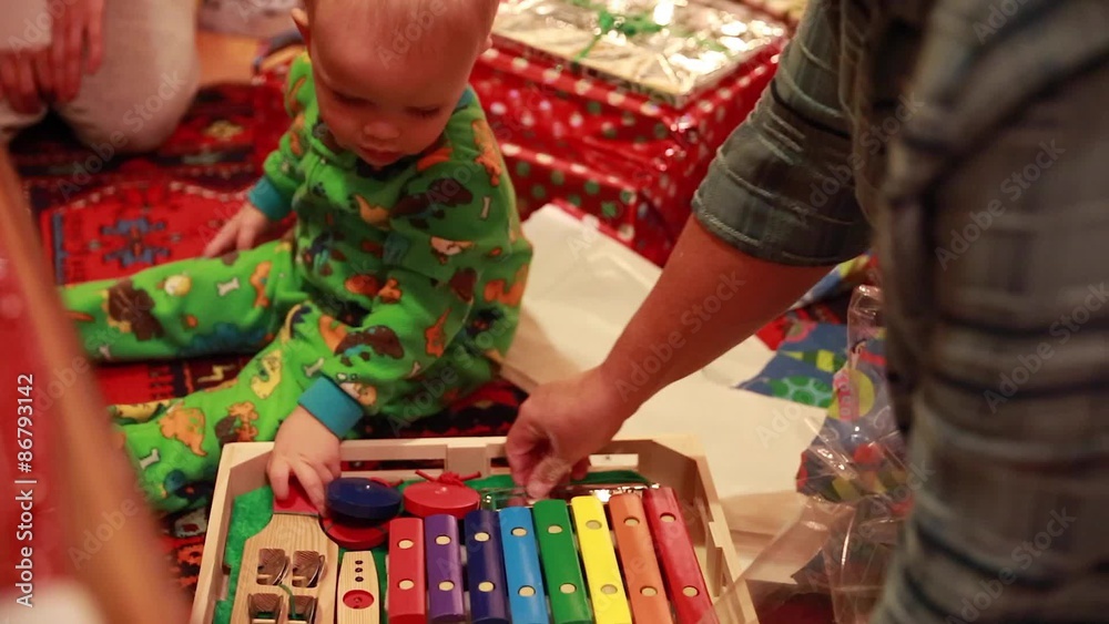 a boy opening his christmas presents in his pajamas a boy opening his christmas presents in his pajamas