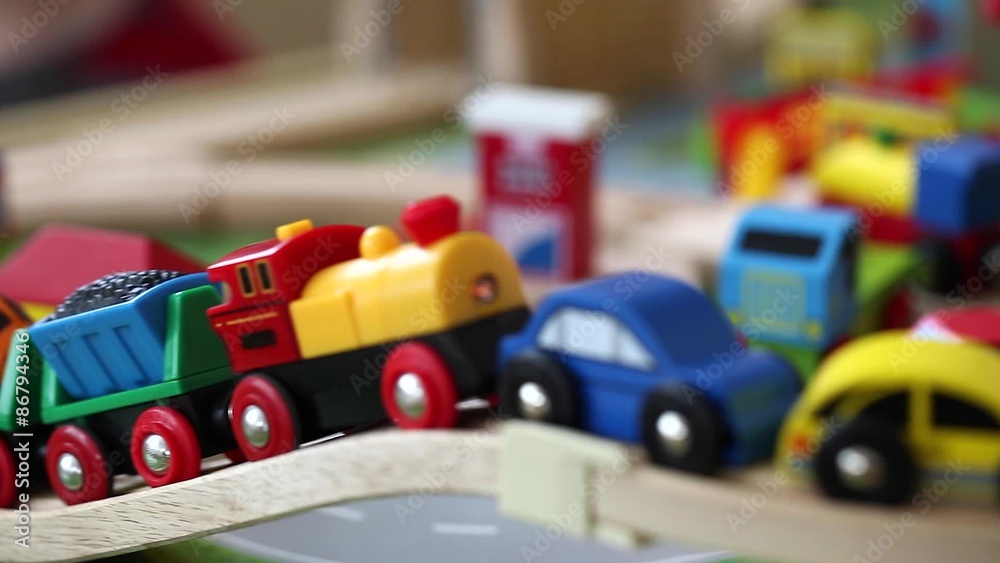 a toddler playing with his toy trains and cars on track