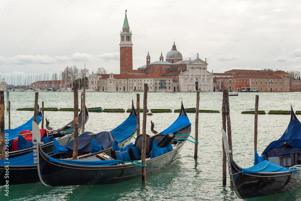 Gondolas moored in the Venice lagoon, with the 