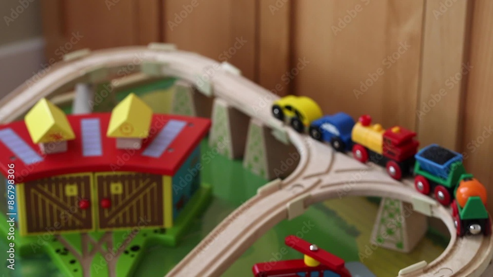 a boy playing with toy trains and cars on track