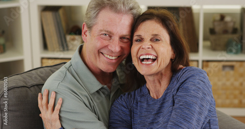 Sweet senior couple cuddling on couch