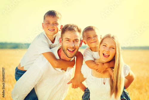 Happy young family on wheat summer field