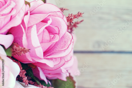 Pink roses against a wood wall