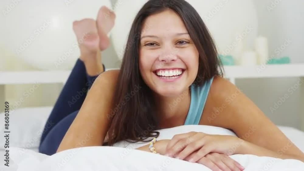 Cute Hispanic woman talking to camera while lying in bed Cute Hispanic woman talking to camera while lying in bed