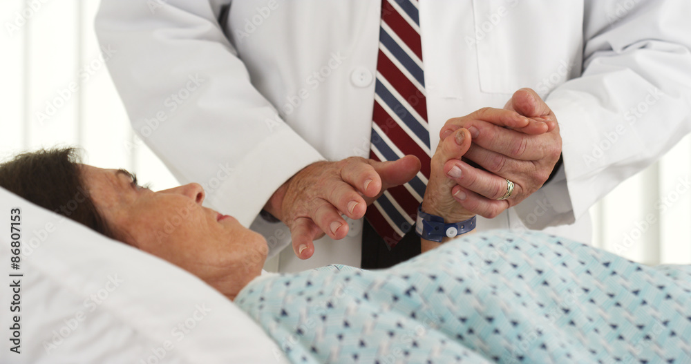 Doctor holding patient's hand and comforting her Doctor holding patient's hand and comforting her