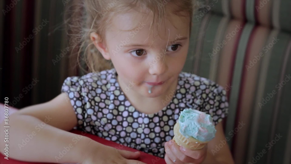 a little girl eating ice cream at a parlor a little girl eating ice cream at a parlor