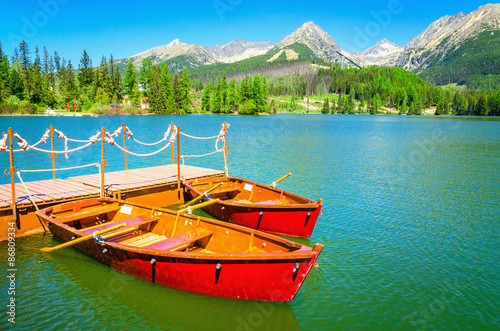 Red wooden boats on mountain lake in Slovakia