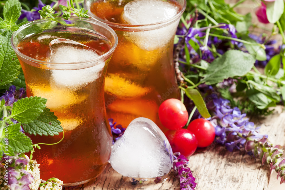 Ice black tea with herbs, selective focus