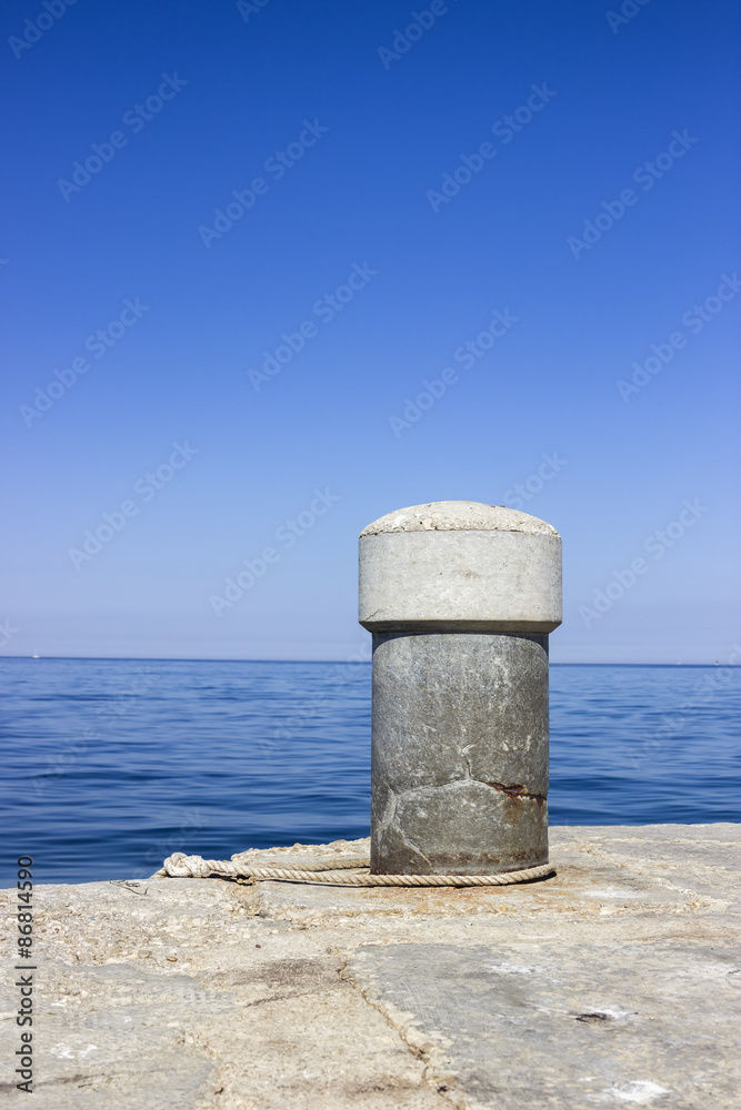 Concrete bollard in the harbor with the sea rope Concrete bollard in the harbor with the sea rope