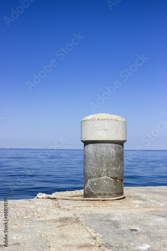 Concrete bollard in the harbor with the sea rope © kalpis