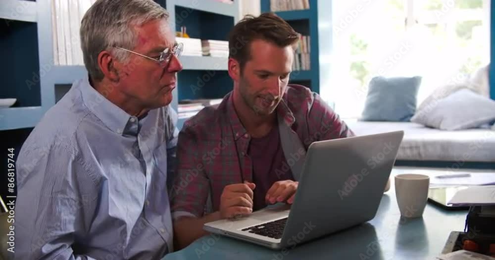 Son Helping Senior Parent With Computer In Home Office Son Helping Senior Parent With Computer In Home Office
