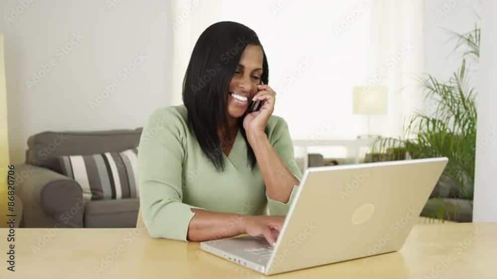 African senior woman talking smartphone and using computer African senior woman talking smartphone and using computer