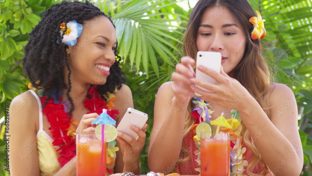 Two best friends on vacation laughing and using smart phones Two best friends on vacation laughing and using smart phones