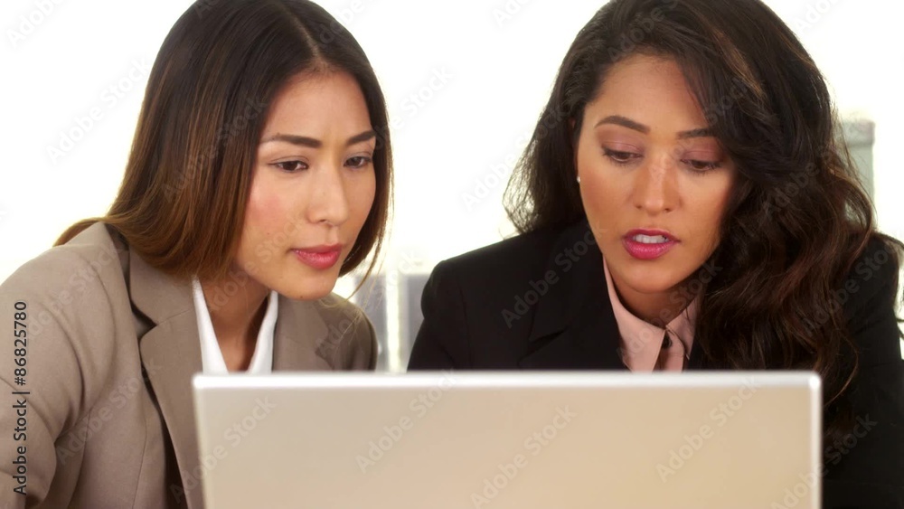 Mixed race business colleagues working on laptop Mixed race business colleagues working on laptop