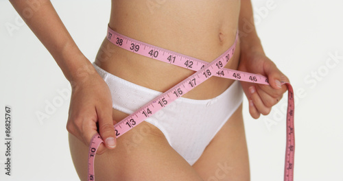 Fit woman measuring waist