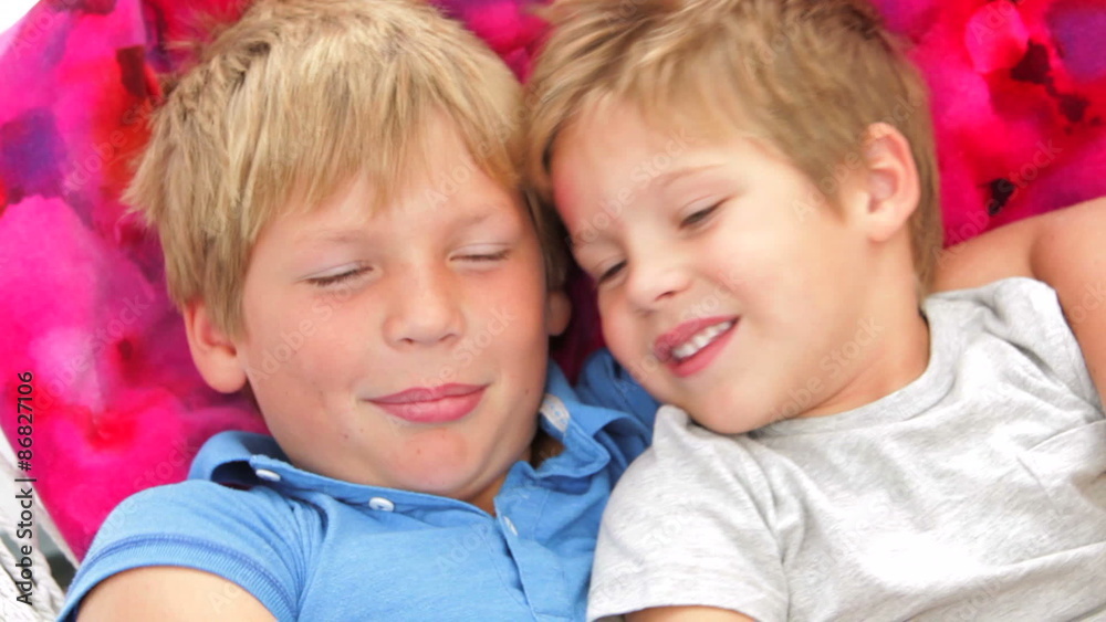 Two Boys Relaxing In Garden Hammock Together Two Boys Relaxing In Garden Hammock Together
