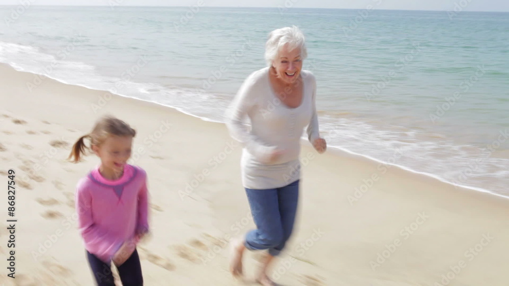Grandmother And Granddaughter Running Along Beach Together Grandmother And Granddaughter Running Along Beach Together