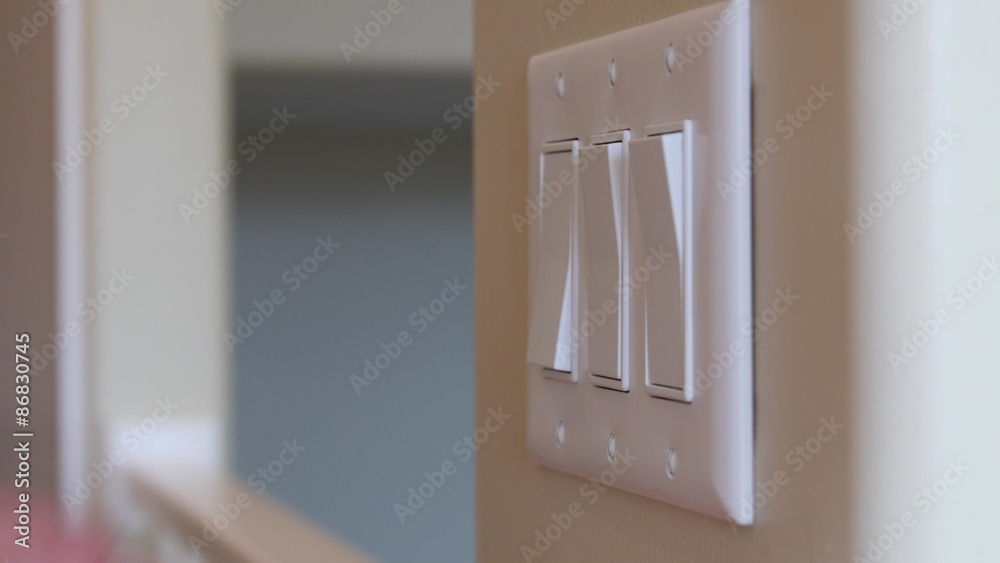 A man turns a light switch on and off