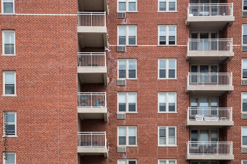 Typical apartment building exterior with brick, windows and balconies