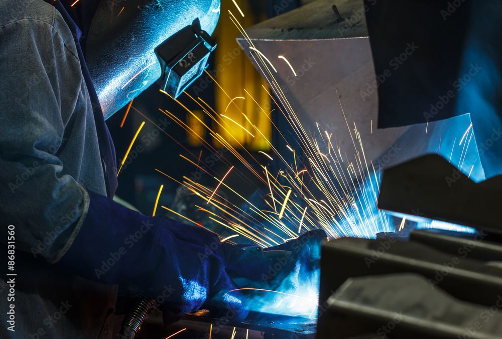 worker welding in production line