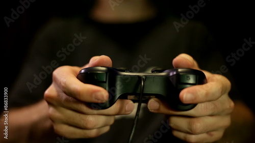 Male playing game on Joystick/gamepad while dark in room photo
