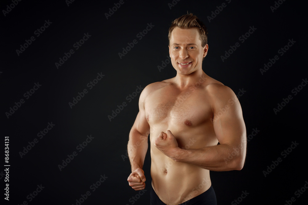 Cheerful young sportsman is flexing his bicep Cheerful young sportsman is flexing his bicep