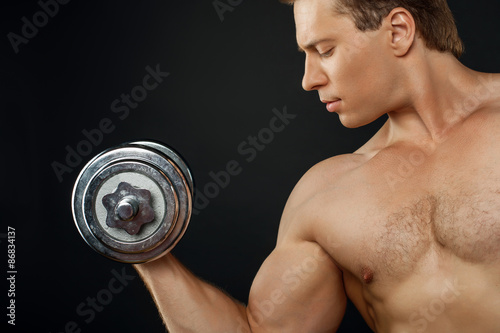 Handsome young man is exercising with iron equipment