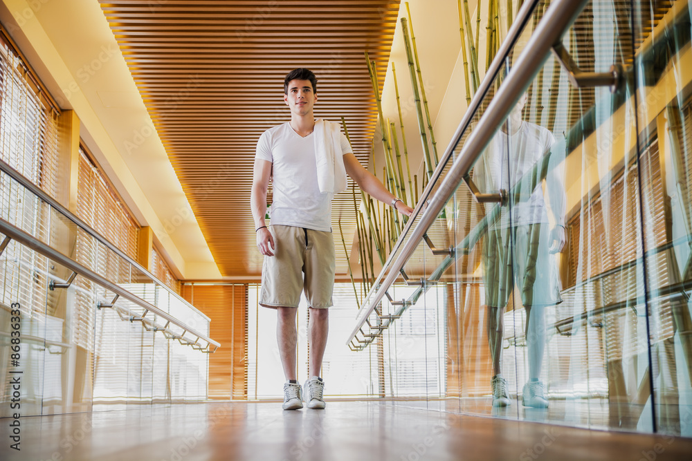 Young Man Standing in Hallway Holding Hand Rail