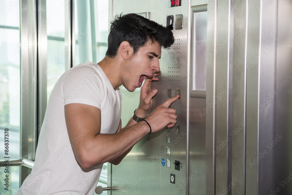 Scared young man desperate in stuck elevator Scared young man desperate in stuck elevator