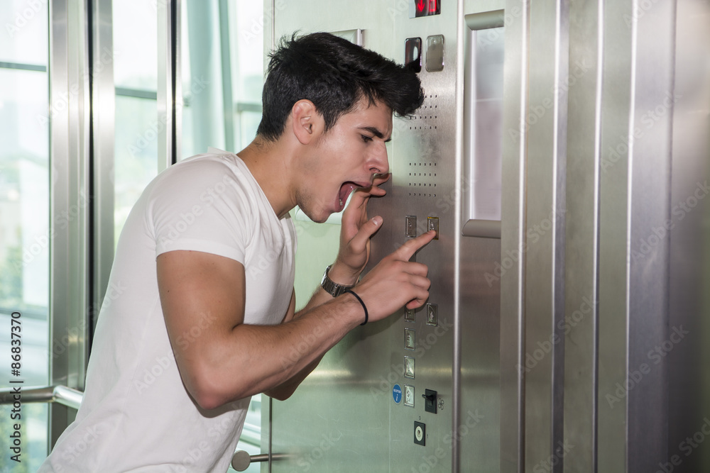 Scared young man desperate in stuck elevator