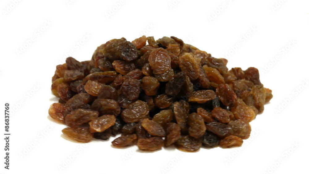 Heap of dried raisins rotating on white background