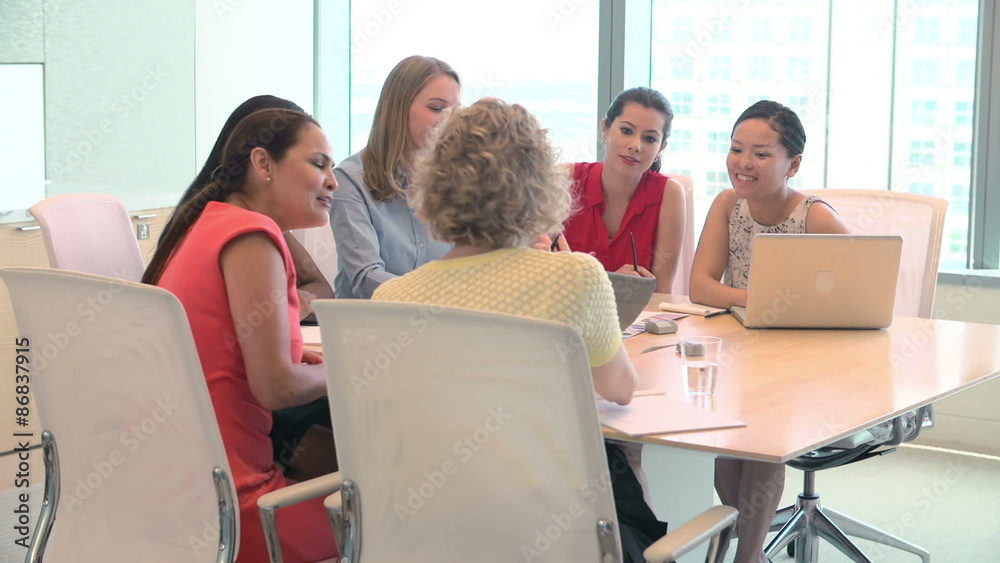 Group Of Businesswomen Meeting Around Desk In Office Group Of Businesswomen Meeting Around Desk In Office