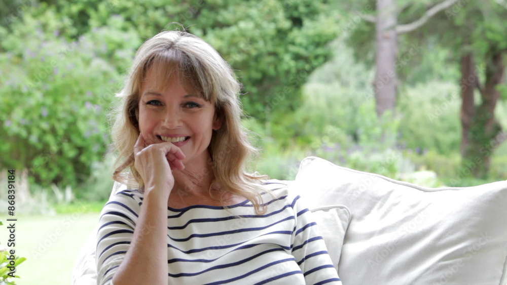 Attractive Middle Aged Woman Sitting Outdoors And Smiling Attractive Middle Aged Woman Sitting Outdoors And Smiling