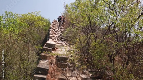 people hiking the unrestored section of the great wall of china photo