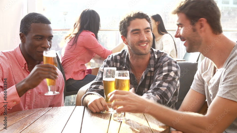 Three Male Friends Enjoying Drink At Outdoor Rooftop Bar Three Male Friends Enjoying Drink At Outdoor Rooftop Bar