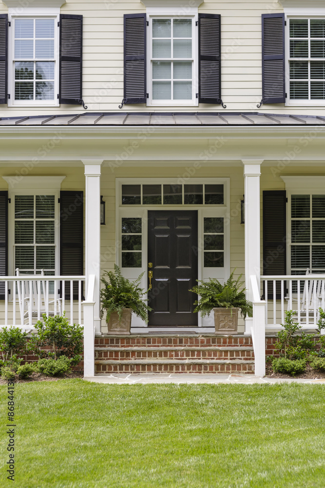 Naklejka premium White colonial house with a porch and plants