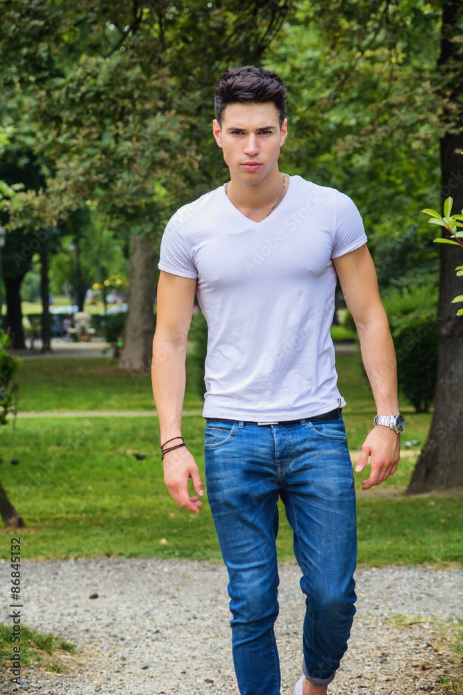 Handsome young man in white t-shirt outdoor in city park Handsome young man in white t-shirt outdoor in city park