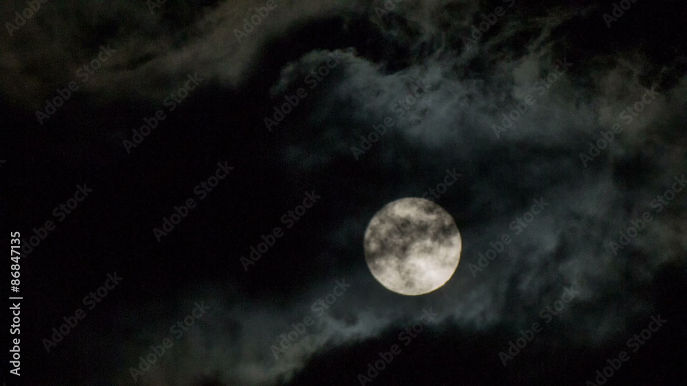 Moon behind the clouds at night close up Moon behind the clouds at night close up